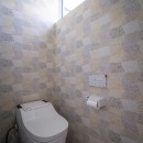 シンプルで落ち着いた壁紙が自然と部屋に馴染む。風合いを演出するデザイン。の写真 壁面に遊びを入れたトイレ