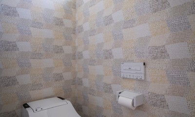 シンプルで落ち着いた壁紙が自然と部屋に馴染む。風合いを演出するデザイン。 (壁面に遊びを入れたトイレ)