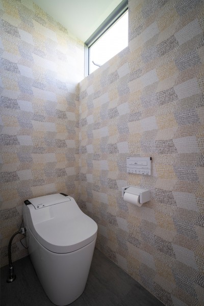 壁面に遊びを入れたトイレ (シンプルで落ち着いた壁紙が自然と部屋に馴染む。風合いを演出するデザイン。)