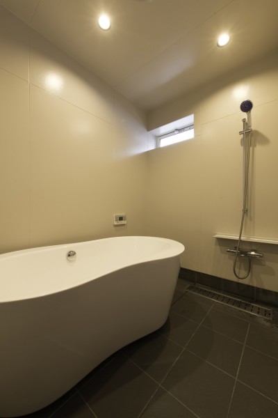 据置バスタブの在来浴室 (”キタムキ　ノ　イエ”　北側の自然豊かな眺望を借景としながら、環境シミュレーションで住環境を最適化した住宅)