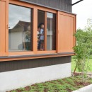 田園のガレージハウス／焼杉板と片流れ屋根の連なる家の写真 木製建具