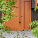 田園のガレージハウス／焼杉板と片流れ屋根の連なる家の写真 玄関扉とエントランスガーデン