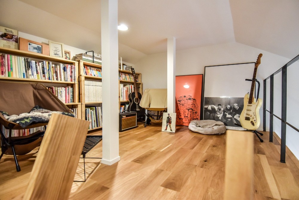 幸せな実家2世帯住宅リノベーション (ロフトの本棚とフレームとエレキギター)