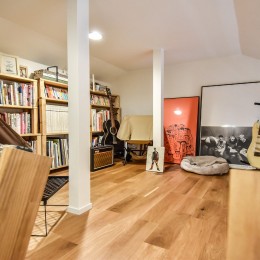 幸せな実家2世帯住宅リノベーション (ロフトの本棚とフレームとエレキギター)