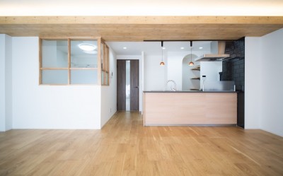 対面キッチンが主役！シックなデザインで統一感ある空間｜4人暮らし・126.06平米 (リビングからキッチンにかけて)