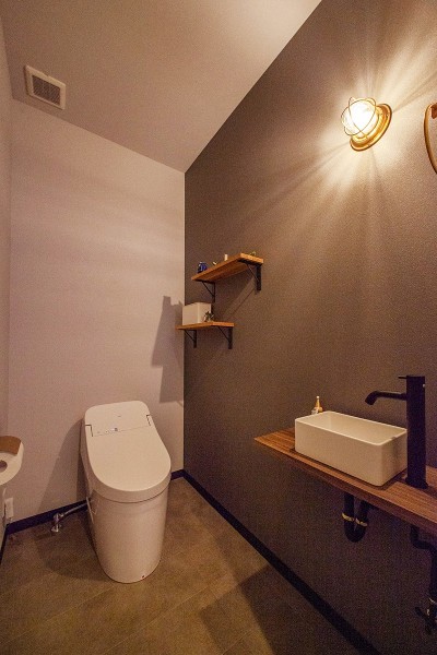来客が多いのでシンプルにまとめ清掃性の高さにも配慮。照明が印象的なトイレに (キッチンをエンターテイメントにする、料理人のパパのステージ)