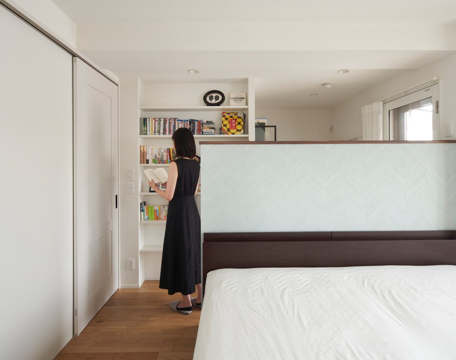 ベッドルーム事例：間仕切り壁で分かれる2機能をもつ部屋（夫婦揃ってリモートワーク可能な仕様に。都心を離れ、温もりと清潔感にこだわった家。）