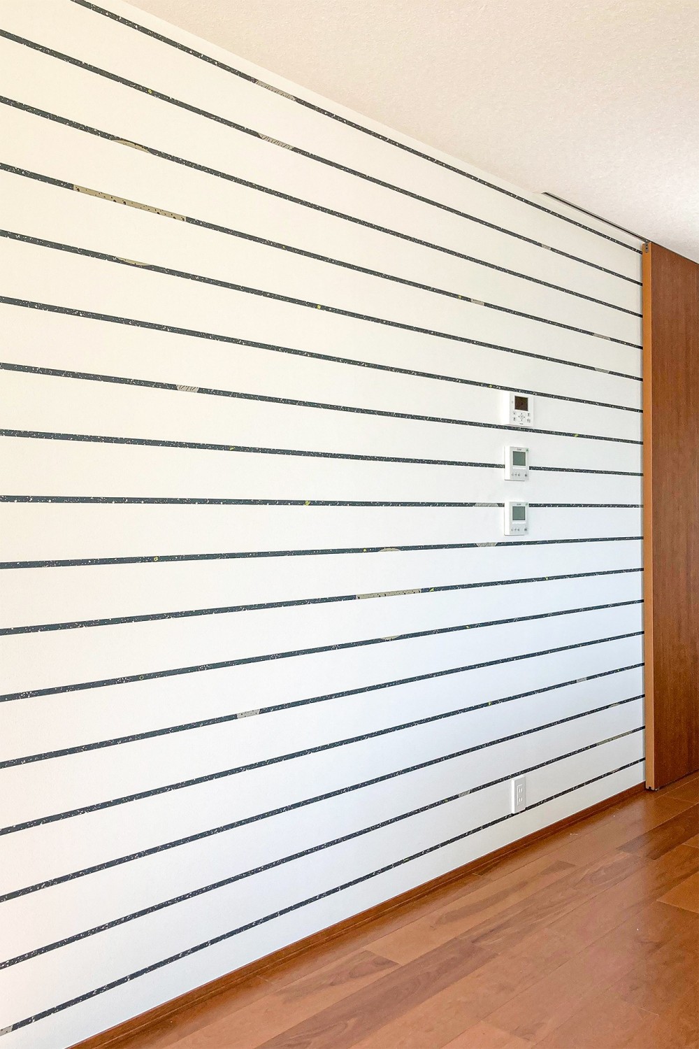 テイストの異なる壁紙を各空間に散りばめる。 (横に伸びるストライプが廊下部分を広く感じさせる)