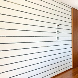 横に伸びるストライプが廊下部分を広く感じさせる (テイストの異なる壁紙を各空間に散りばめる。)