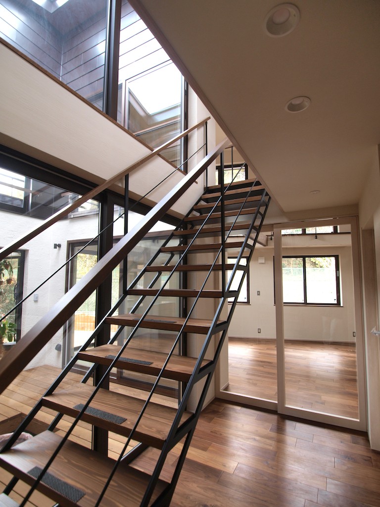 玄関事例：2階へ上がる視線の抜ける階段（中庭と温室のある猫のいる家）