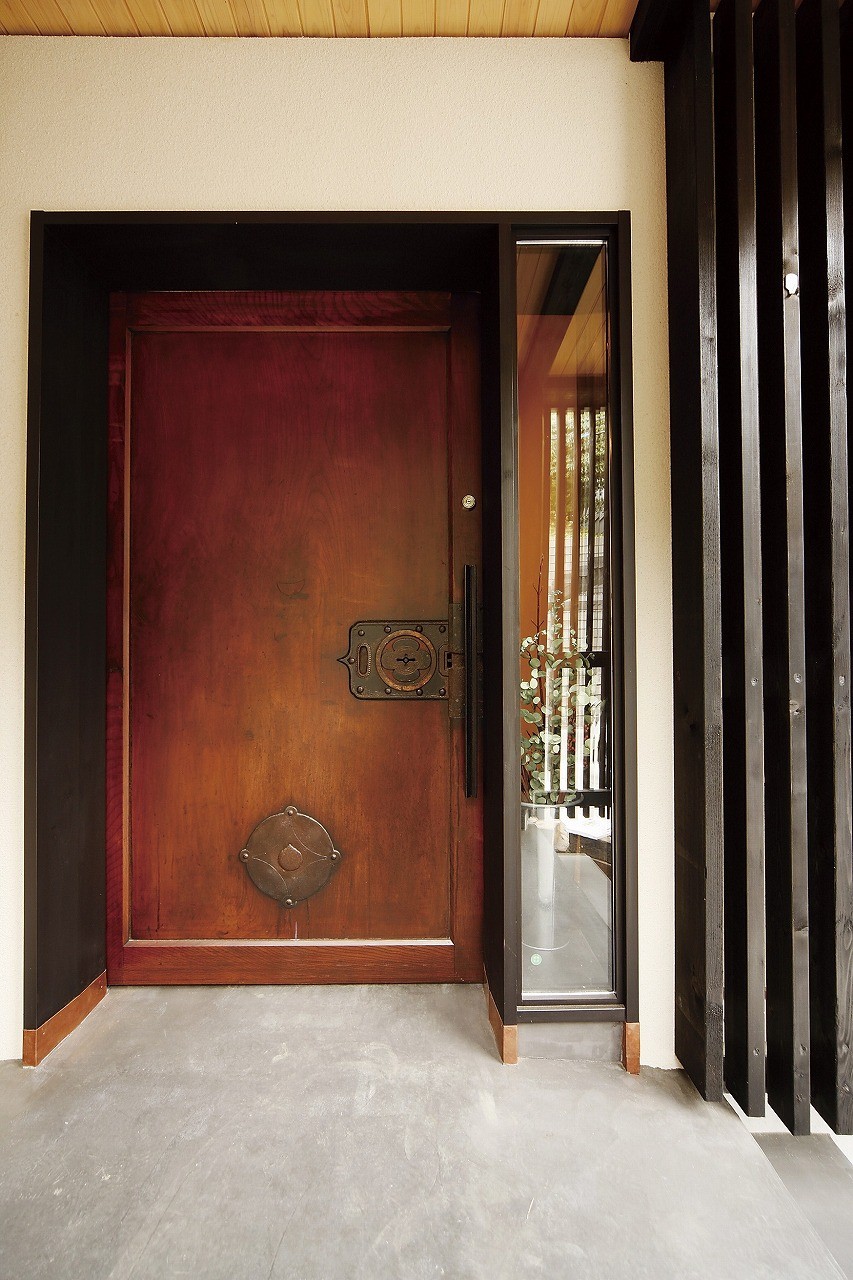 玄関事例：欅一枚板の蔵戸を玄関戸に使う。（SKY FIELD HOUSE『現代古民家』）