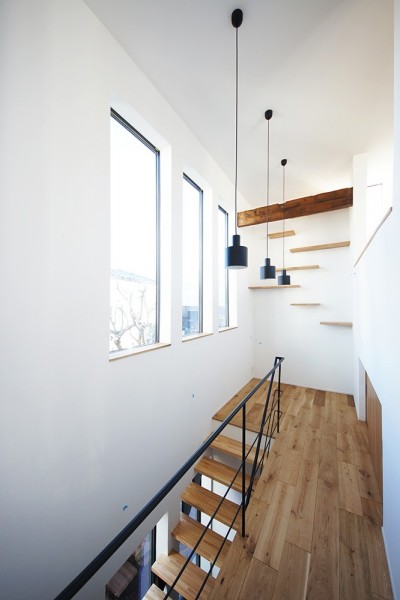 リズミカルな印象の階段ホール (世帯をつなぐ通り土間のある家／東京都世田谷区)