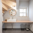 丁寧に作られた注文住宅をできるだけ活かして長く使えるマイホームへの写真 キッチンを広くするために移設した洗面室は階段下もうまく利用してナチュラルなイメージで統一