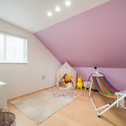 蓮田の家～大きな吹き抜けのある開放感～平屋をイメージしたすまい～ (子供部屋　屋根勾配がそのまま室内の天井になっているロフト風の空間です。アクセントの壁紙(ピンク)はお子さん自身で選定しました。)