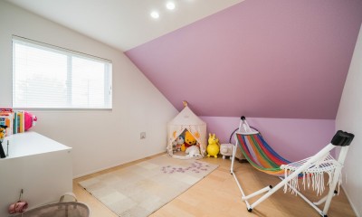 蓮田の家～大きな吹き抜けのある開放感～平屋をイメージしたすまい～ (子供部屋　屋根勾配がそのまま室内の天井になっているロフト風の空間です。アクセントの壁紙(ピンク)はお子さん自身で選定しました。)
