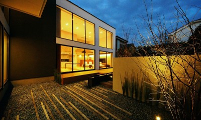 光が水盤に反射する夜の中庭｜インナーガーデンとアウトサイドリビングのある家／東京都
