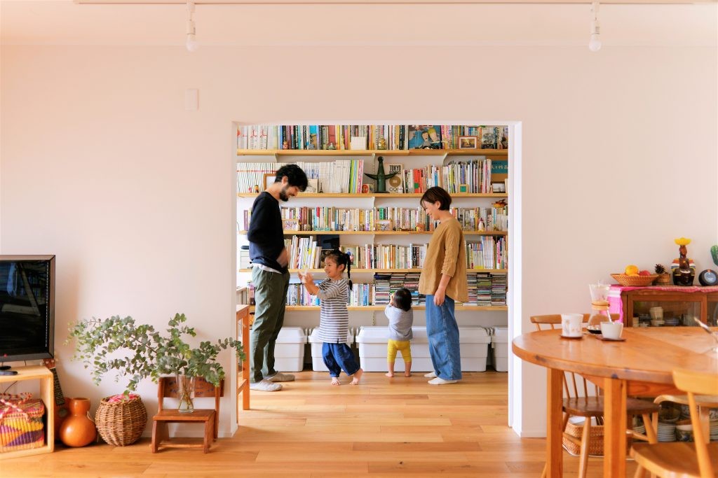 リビングダイニング事例：塗装壁と無垢質感の床と本棚（家族色に描いて。）