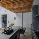 デザイン性と快適さを併せ持つ三角形のモダンハウスの写真 ルーバー天井が印象的なダイニングキッチン