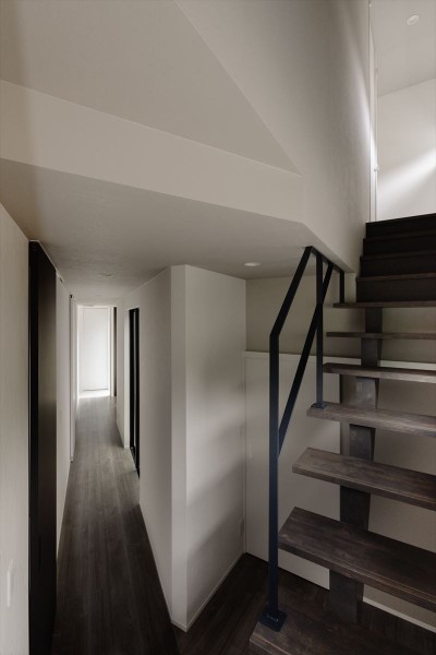木製のスケルトン階段とアイアン手すり (デザイン性と快適さを併せ持つ三角形のモダンハウス)