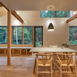 草津別荘ー森の中でひっそりと過ごす家ー (キッチンから森を眺める。照明点灯時。)