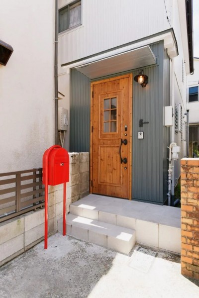 緑のガルバリウム外壁とウッド調の玄関ドア、赤いポストが可愛らしい (築54年の中古木造住宅を、終の棲家に)