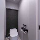 愛猫をめでるセンターデスクと隔離型のダブルワークスペースの写真 シンプルに徹したモノトーンのトイレ空間