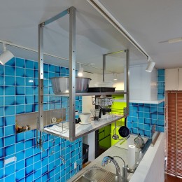下がり壁を無くしてオープンタイプのステンレスの棚を設置。青のタイルが印象的なオープンキッチン (それぞれのマイスペースとLDK)