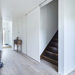 階段の引き戸 (継承した家をたくさんの人が集まりやすいシンプルかつモダンな空間に)