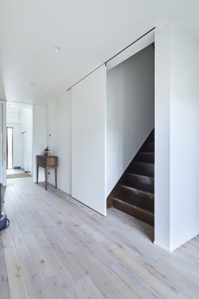 継承した家をたくさんの人が集まりやすいシンプルかつモダンな空間に (階段の引き戸)