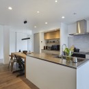 継承した家をたくさんの人が集まりやすいシンプルかつモダンな空間にの写真 アイランドキッチンと壁付けコンロ側キッチン
