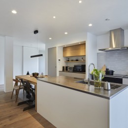 継承した家をたくさんの人が集まりやすいシンプルかつモダンな空間に (アイランドキッチンと壁付けコンロ側キッチン)