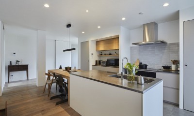 継承した家をたくさんの人が集まりやすいシンプルかつモダンな空間に (アイランドキッチンと壁付けコンロ側キッチン)