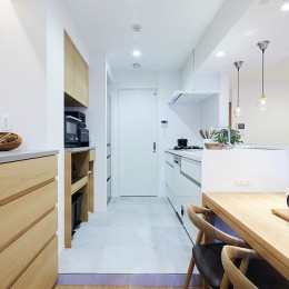 キッチンとランドリースペース (永く住むために自分達に合ったシンプルな暮らしを叶えたマンションリノベーション)