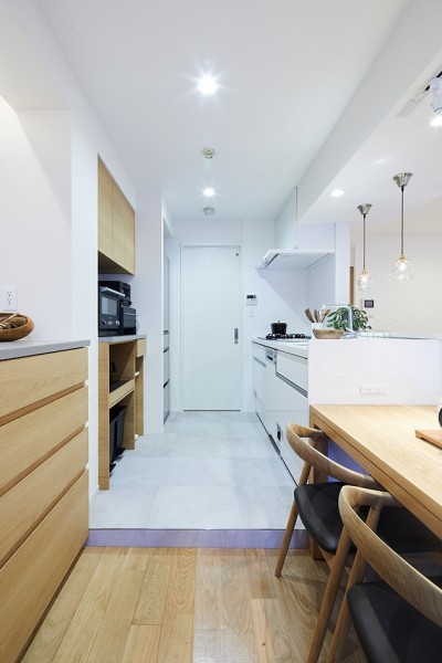 キッチンとランドリースペース (永く住むために自分達に合ったシンプルな暮らしを叶えたマンションリノベーション)