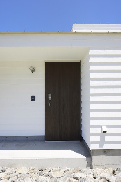白い外壁とこげ茶のドアのコントラスト (岩井のビーチハウス～スローライフを楽しむ海の家)