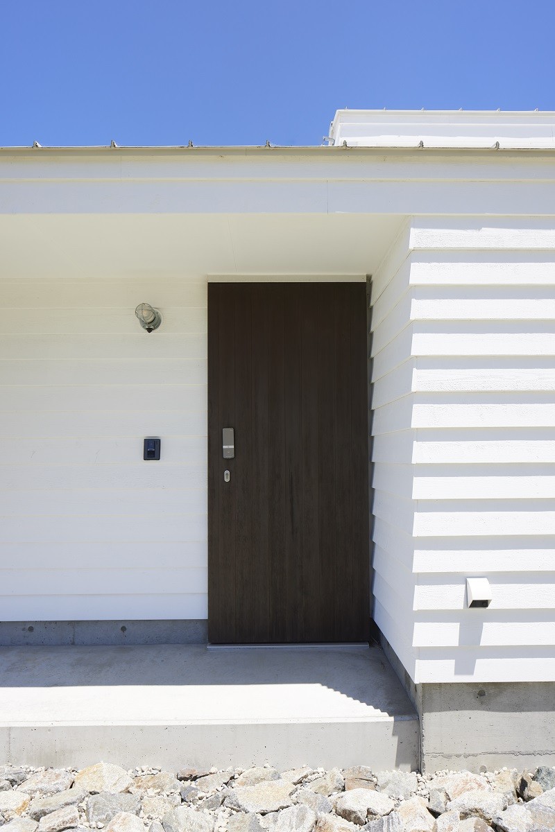 玄関事例：白い外壁とこげ茶のドアのコントラスト（岩井のビーチハウス～スローライフを楽しむ海の家）