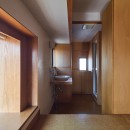 長大な壁面収納のある集合住宅リノベーションの写真 ベッドスペースから脱衣洗面スペースを見る