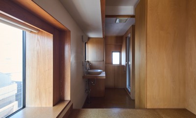 長大な壁面収納のある集合住宅リノベーション (ベッドスペースから脱衣洗面スペースを見る)