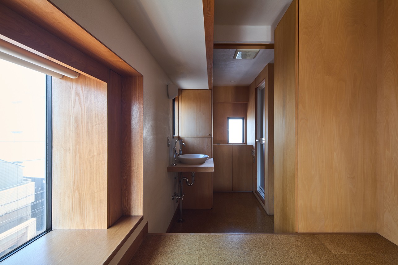 バス/トイレ事例：ベッドスペースから脱衣洗面スペースを見る（長大な壁面収納のある集合住宅リノベーション）