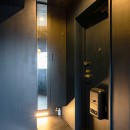 black／white　こだわりのインテリアの為のリノベーションの写真 黒で統一した玄関ホールの上下に照明を配して空間の形を浮かびあがらせています。