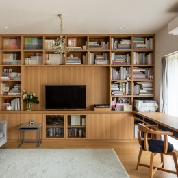壁一面の本棚とワークスペースがあるリビング (お気に入りの本に包まれる 洗練された図書館のような住まい)