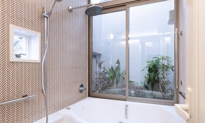 みずまわり回遊　／動線リニューアルと、坪庭にひらかれた高天井風呂 (坪庭に面した浴室)
