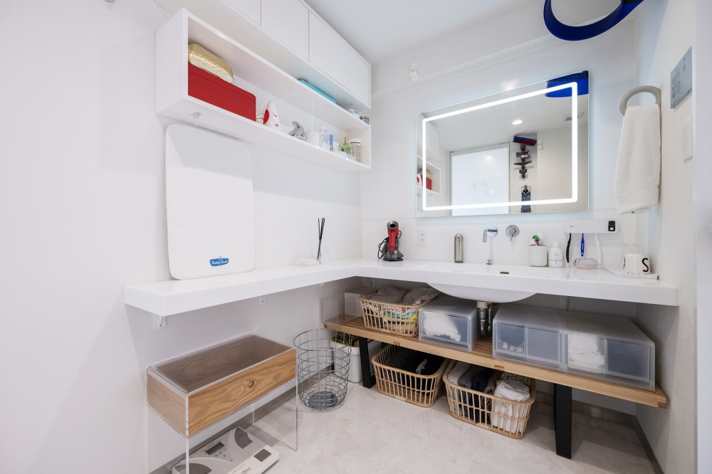 暮らしの背景としての白 (特注で作成した洗面台カウンターはL型に配置され、洗面ボウルは一体型の清掃性の高いものに。側面のカウンターは便利で、身支度、家事で活用しています)