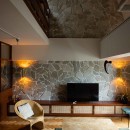 ヴィンテージ家具が似合うメゾネットの贅沢な空間の写真 吹き抜けと壁が特徴的なリビング。