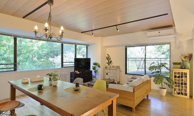 デザイナーのホーム＆オフィス (窓外に広がる緑を楽しめるように配置したソファとダイニング)