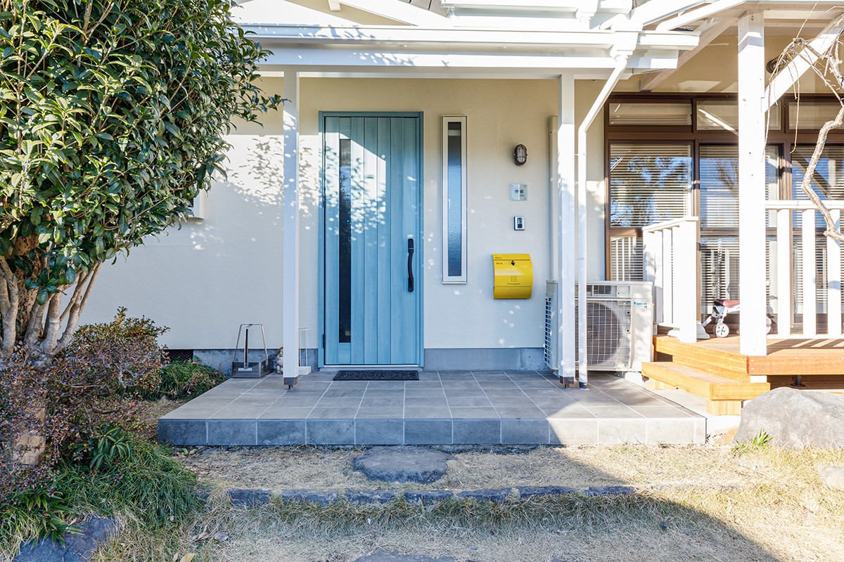 玄関事例：外観をカリフォルニアスタイルにする水色の玄関ドアに、黄色のポストをアレンジ（寄り添う2つのLDK）