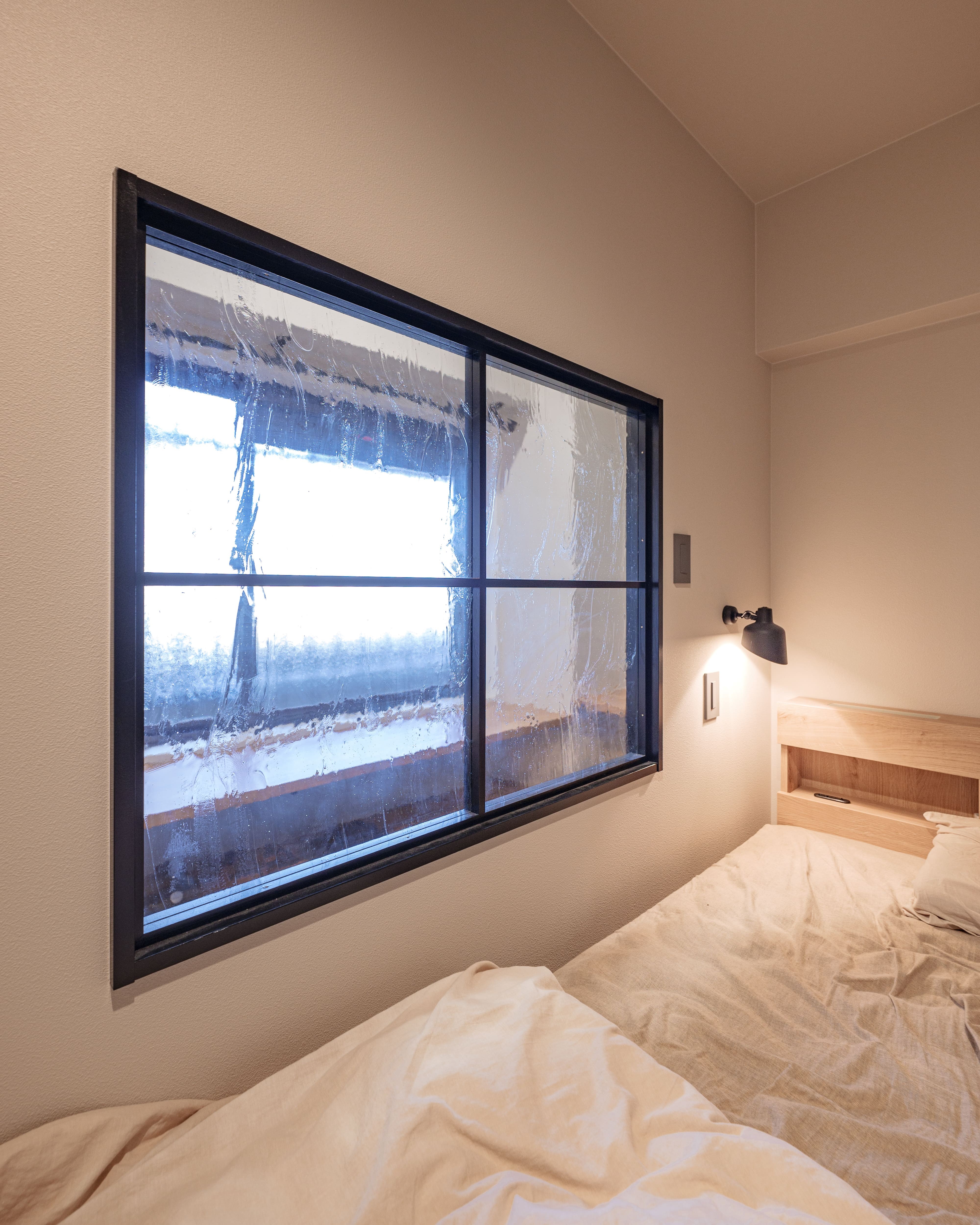 ベッドルーム事例：開放感をつくる室内窓（武骨なインダストリアルと木の温もり感じるナチュラルの調和）