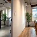無機質な雰囲気にこだわった作業が捗るモダンなオフィスの写真 ワークスペースとミーティングルームで異素材の床