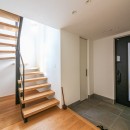 吹き抜けと空中回廊のある家／東京都目黒区の写真 階段ホールから光が射す玄関