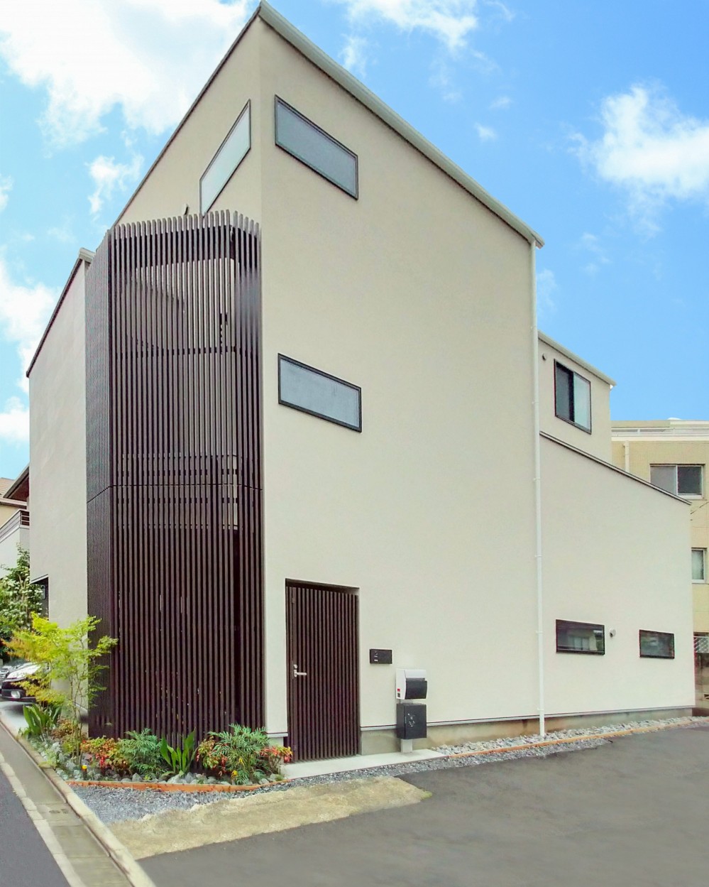 吹き抜けと空中回廊のある家／東京都目黒区 (花壇とルーバーが目を引く外観)